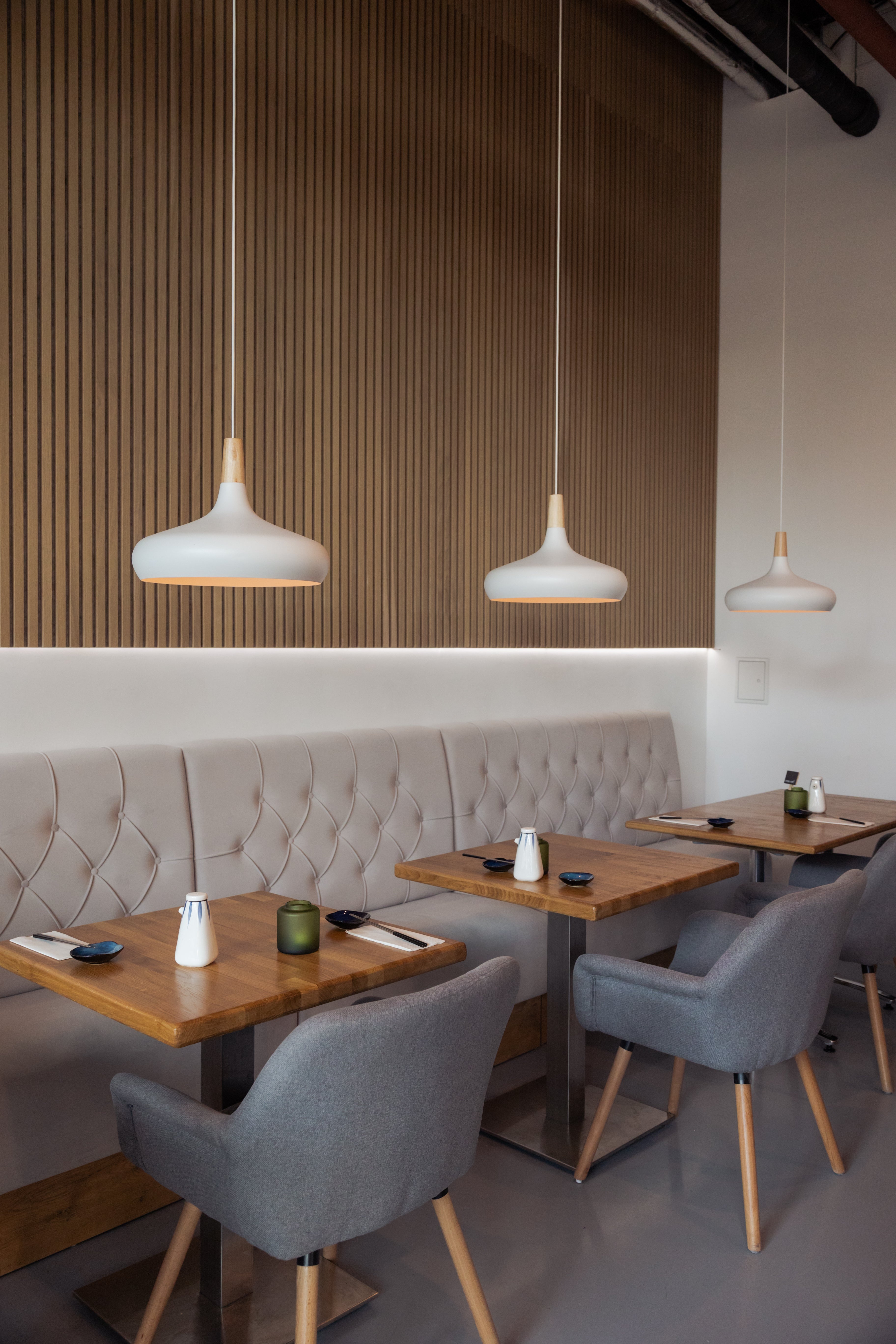 Akupanel acoustic slat wall panels with vertical wood slats on interior dining wall.
